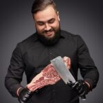 smiling butcher scratching meat with knife fd5wrhn.jpg